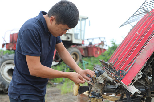 王程淋在修理農(nóng)機(jī)設(shè)備.jpg 王程淋在修理農(nóng)機(jī)設(shè)備.jpg