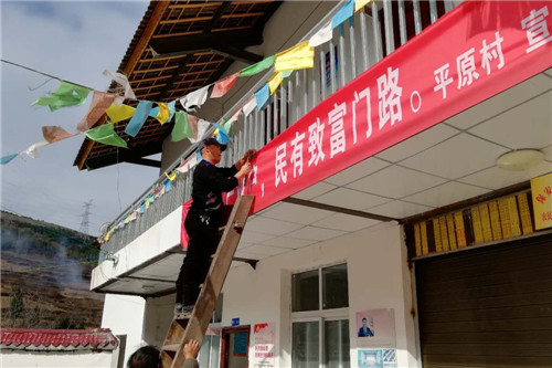 駐村援彝的王志輝 在村里上掛宣傳標(biāo)語.jpg