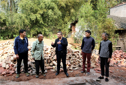 瀘州市納溪區(qū)農(nóng)業(yè)農(nóng)村局畜牧專家胡南到納溪區(qū)龍車鎮(zhèn)大堰村脫貧戶楊學(xué)澄家里，指導(dǎo)他修建黑山羊養(yǎng)殖場 王超明攝.jpg