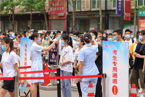 圖為考生進入考場前排隊進行體溫監(jiān)測 寧先民攝.jpg