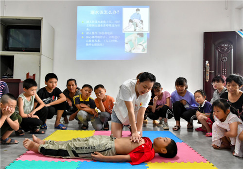 廣安區(qū)紅十字會工作人員周小娟為孩子們講解溺水后的心肺復(fù)蘇急救知識.jpg